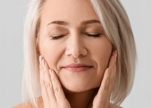 Older woman with great skin touching her face