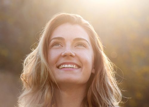 Smiling woman standing in the sunlight