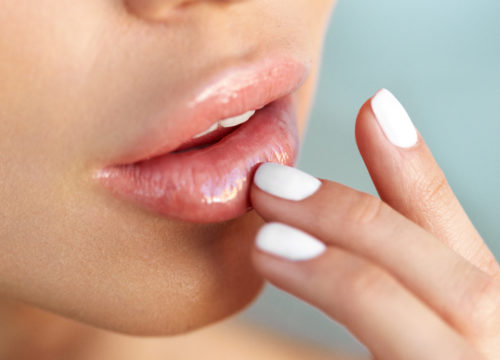 A closeup of a woman touching her lips