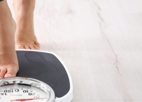 Woman stepping on a scale.
